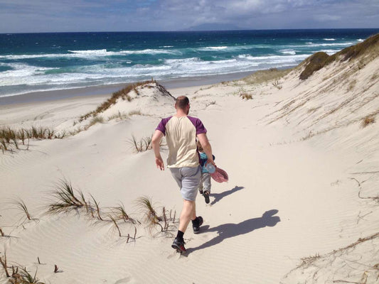 Ein Mann in Woll-Kleidung am Meer in der Sonne
