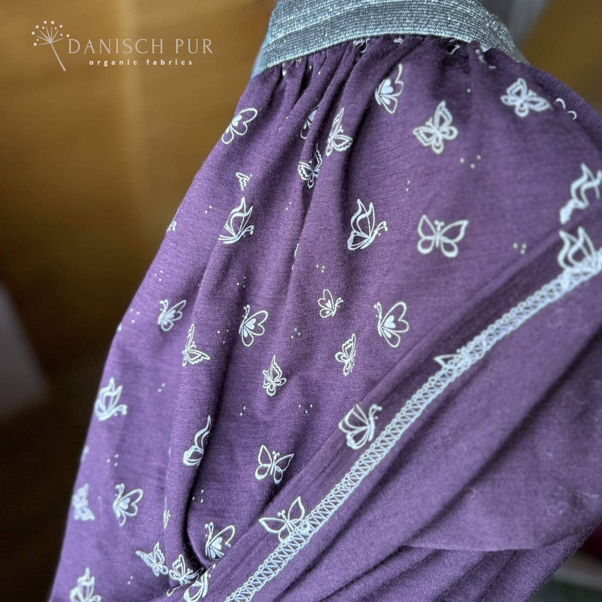 Singlejersey Bio Wolle Seide Schmetterlinge auf Aubergine (70% Schurwolle Merino, kbt, mulesingfrei, 30% Seide)