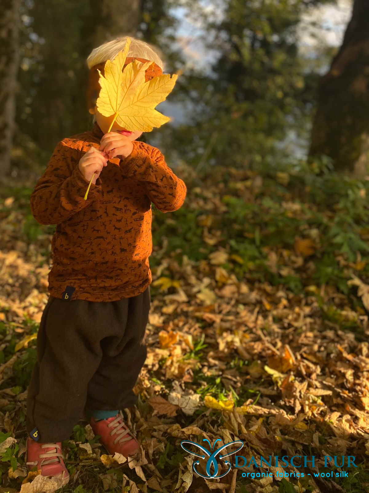 Kind im Wald mit Blatt vor dem Gesicht